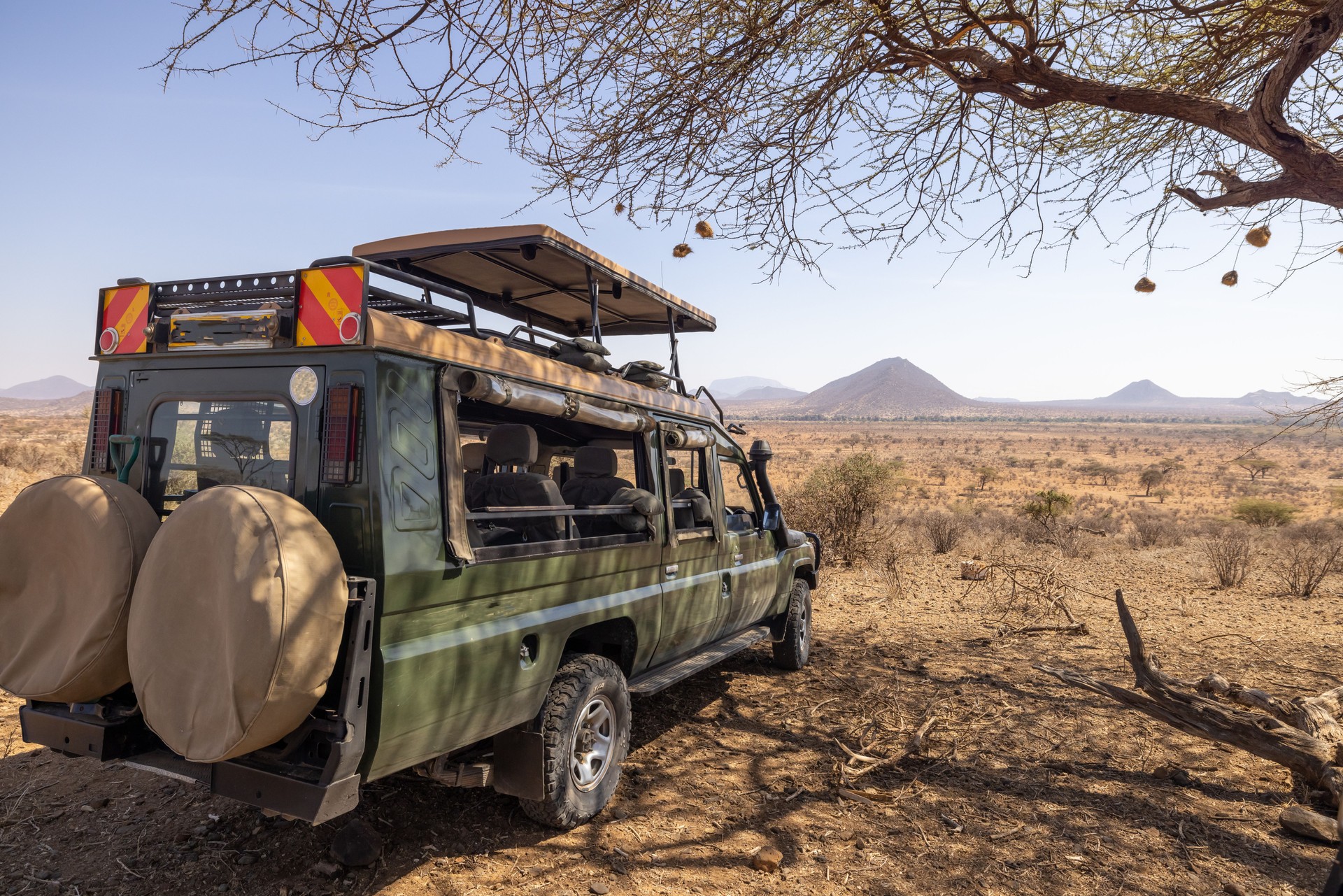 Off-road vehicle parked on arid landscape against clear sky at National Park in Kenya,East Africa during sunny day